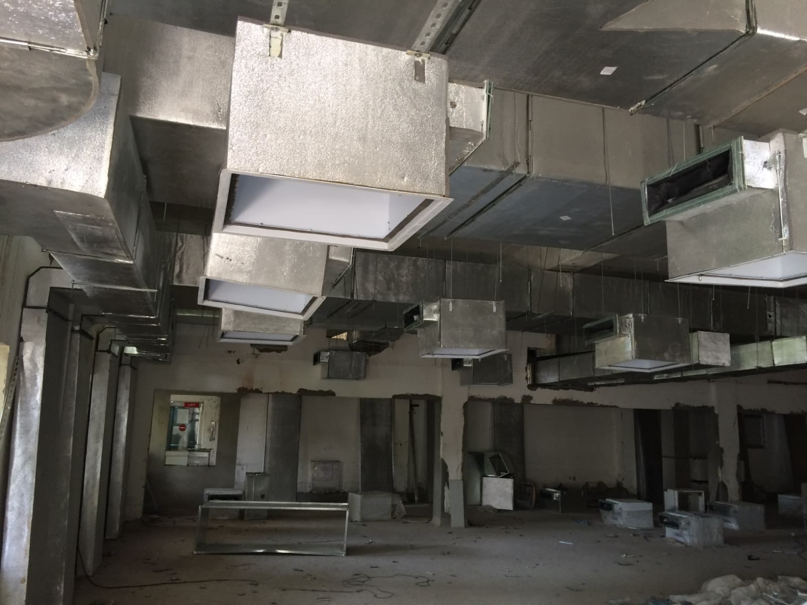 Insulated GI supply ducting with diffuser boxes installed overhead at a construction site